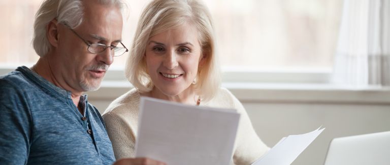 Banner image of middle-aged couple reviewing documents
